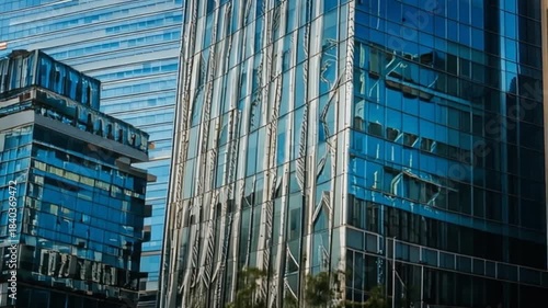 Modern Glass Skyscrapers Reflecting Blue Sky and Clouds in Urban Cityscape.