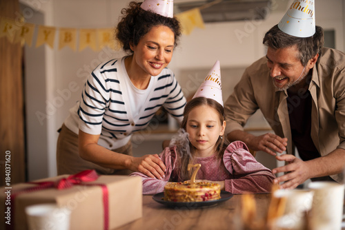 Vászonkép Family Celebrating a Child's Seventh Birthday with a Cake and Decorations