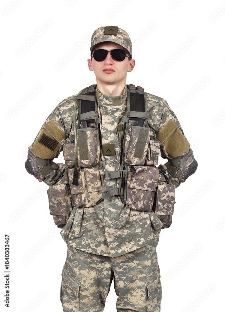 Obraz premium An American soldier in camouflage uniform and sunglasses stands with his hands behind his back
