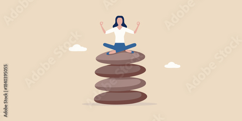 Woman meditating in lotus position atop a balanced stone tower
