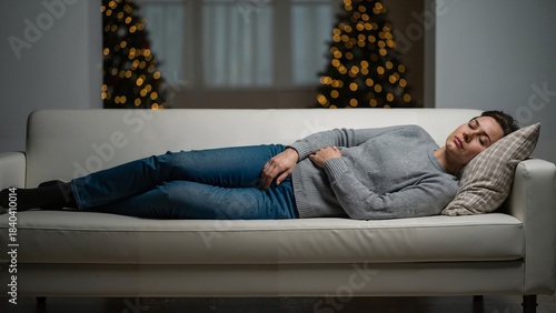 Woman resting on couch with pain in winter living room decor  