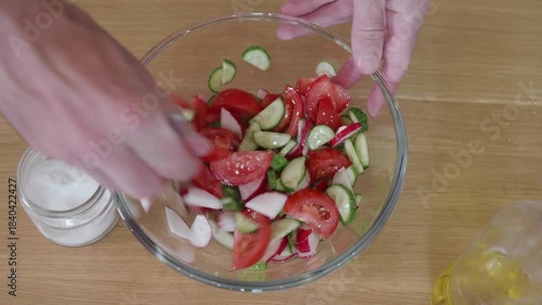 Adding Olive Oil to a Fresh Vegetable Salad, Pouring Dressing onto Sliced Tomatoes, Cucumbers, and Radishes for a Healthy Meal.