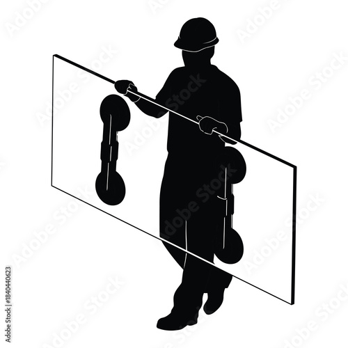 Silhouette of construction worker carrying large pane of glass with suction cups