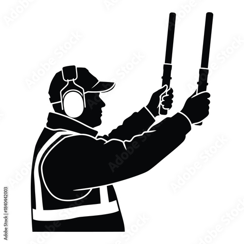 Silhouette of airport marshaller signaling aircraft with wands