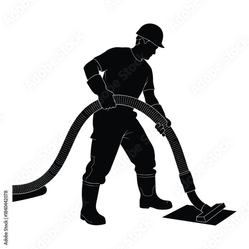 Silhouette of a worker using a vacuum hose for industrial cleaning or suction