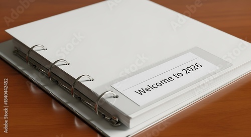 A binder with a welcome to 2026 label on a wooden surface