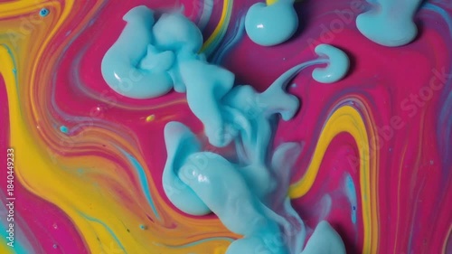 Vibrant fuchsia yellow and light blue liquid art creating mesmerizing swirling patterns and organic shapes as paints blend dynamically in an abstract fluid composition