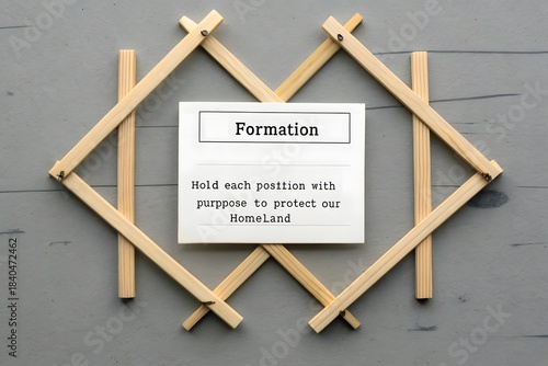 Wooden sticks arranged in tactical grid around a formation message