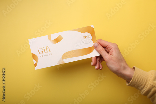 Top view of woman holding gift voucher lettering on white background
