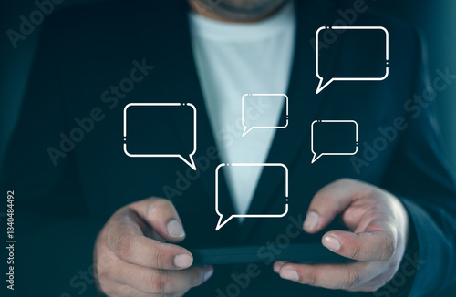 Professional using mobile device with live chat speech bubbles, emphasizing customer service and online communication, phone, and speech bubbles.