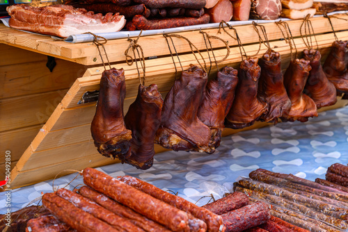 A variety of smoked and cured meat products at a market. 