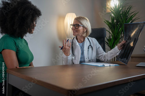 Confident doctor reviewing spine MRI results with African female patient