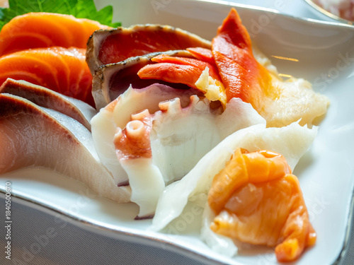 Raw seafood, sashimi, sliced on white dish in luxury restaurant, tuna, octopus, salmon, clam, scallop, squid, served in Japanese style