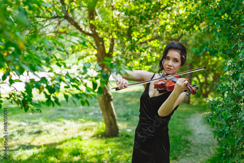 Violinist performing gracefully in a lush green garden