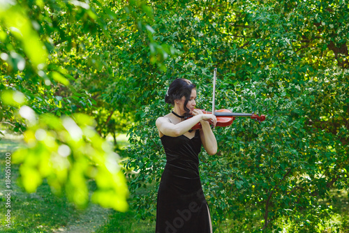 Violinist playing in a lush green garden