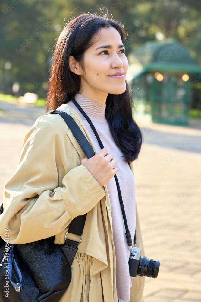 Naklejka premium woman camera backpack outdoors park sunlight travel fashion casual relaxed exploring sunny park with camera ready moments in nature during outdoor stroll and serene mood in daylight