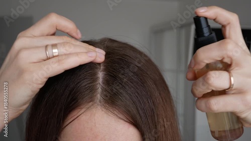 Wallpaper Mural A woman applies hair growth spray to her scalp. Macro shot showing a close-up of the hair part. Concept for hair loss treatment, scalp care, and trichology. Torontodigital.ca