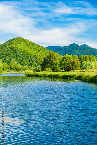 Beautiful river Gacka flowing between the green meadow fields in Lika region, Croatia 