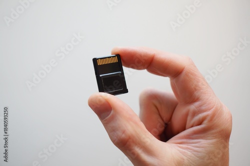 hand holding cf-express a memory card. Caucasian hand holding type A CFexpress memory card. Holding a flash memory card.