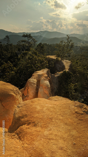 Scenic landscape of Pai Canyon near Chiang Mai, featuring narrow sandstone ridges, warm sunset light, tropical vegetation and dramatic mountain views in northern Thailand.