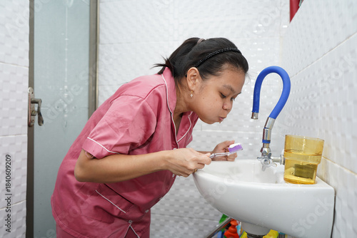 Woman Rinsing Mouth After Brushing Teeth
