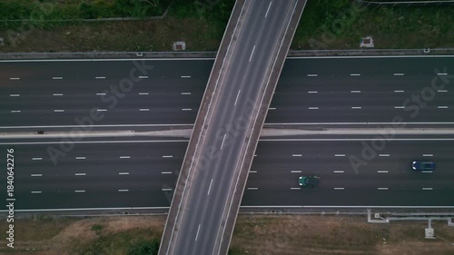 An aerial view of a highway with an overpass and a few cars.