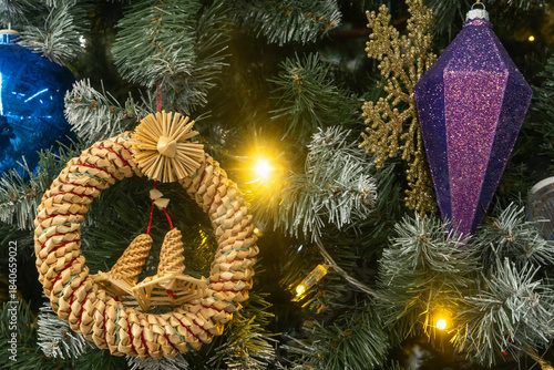 Christmas tree with blue purple and straw ornaments and glowing lights. Where reflection meets nature a tree adorned with symbols of memory craft and seasonal contrast.