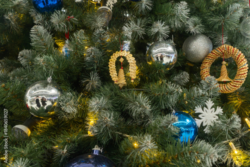 Christmas tree with blue purple and straw ornaments and glowing lights. Where reflection meets nature a tree adorned with symbols of memory craft and seasonal contrast.