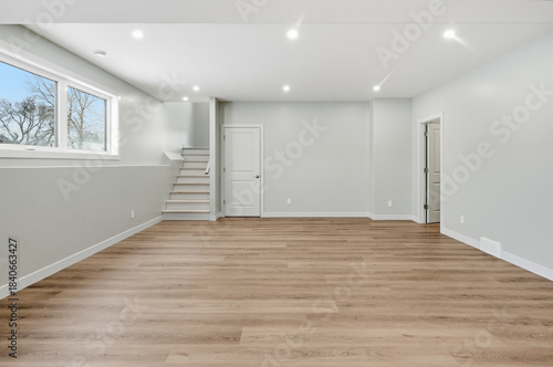 Large, empty room with a wooden floor and white walls