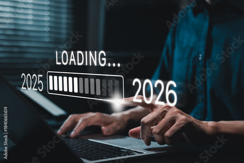 Progress and transition from 2025 to 2026 concept. A person pointing to loading bar transitioning from 2025 to 2026, progress, future planning, and new year goals. annual planning and business growth.