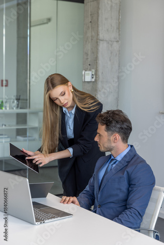 Colleagues working together on a project sitting at one laptop