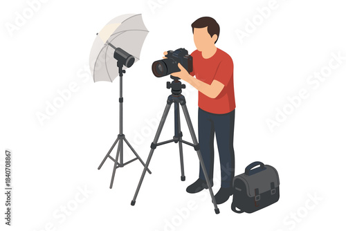 Male photographer with camera and tripod setting up studio lighting equipment