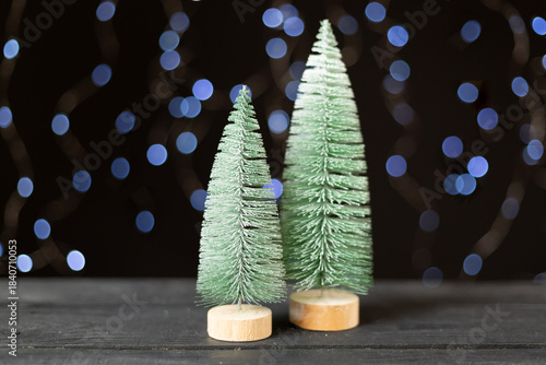 Small christmas trees on table against bokeh background