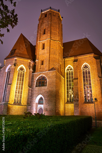 Medieval Gothic church with bell tower at night in Wroclaw