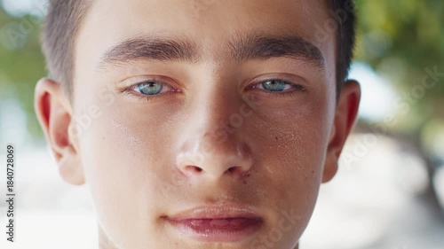 Portrait of the caucasian teen boy with deep eyes of mixed colors looking into the camera