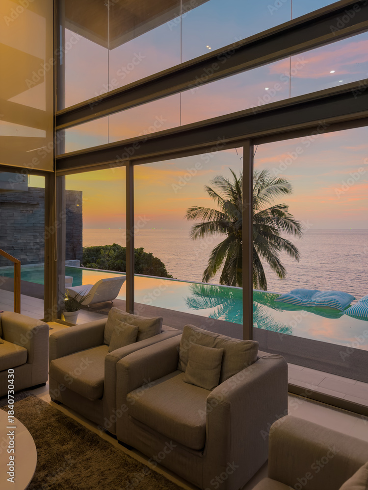 Fototapeta premium View from luxury villa at sunset, sun loungers for sunbathing, umbrellas from the sun, pillows for swimming in the pool, palm tree on background