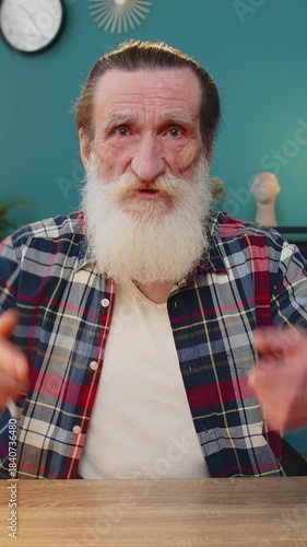 Conflict quarrel negotiation. Portrait of angry senior man engaged in webcam online video call at home office. Upset freelancer grandfather discussing conversation after analyzing financial report.