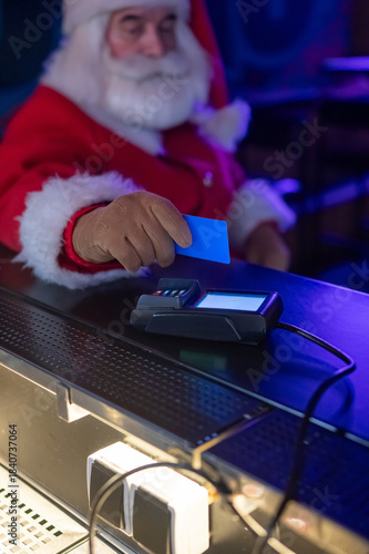 Santa Claus pays with a credit card at a pub. 