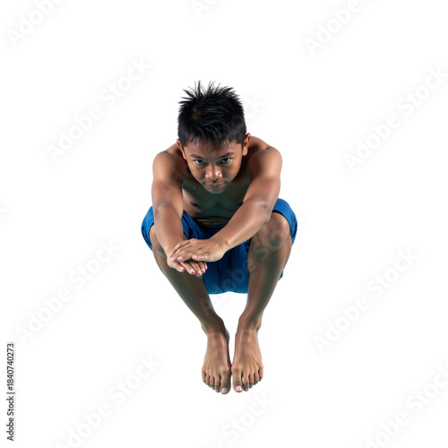 Young boy poised for a dive into the water with anticipation and focus