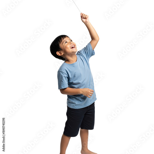 Joyful young boy playing outdoors flying a kite against clear backdrop