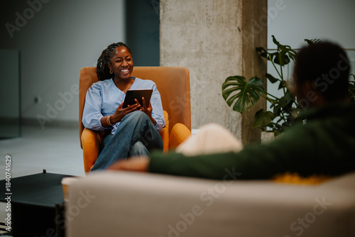 Black woman smiling having business conversation with colleague