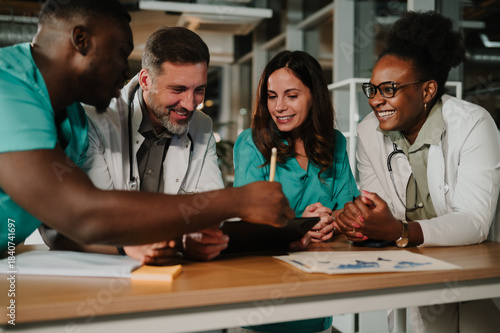 Diverse medical team collaborating on digital tablet