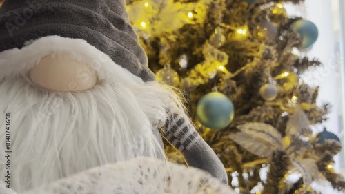 Festive Gnome Near bokeh Decorated Christmas Tree with warm lights