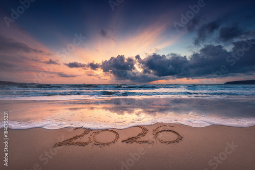 Fototapeta Naklejka Na Ścianę i Meble -  Happy New Year 2026 concept, text lettering on the beach sand at sea sunrise, tropical island sunset and ocean waves