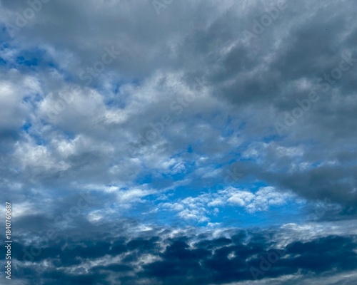 Wolkengebilde in unterschiedlichen Farbtönen vor blauem Himmel
