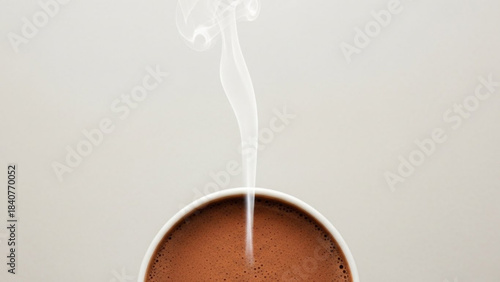 A steaming cup of hot chocolate with a delicate wisp of white smoke rising from its surface isolated on white background