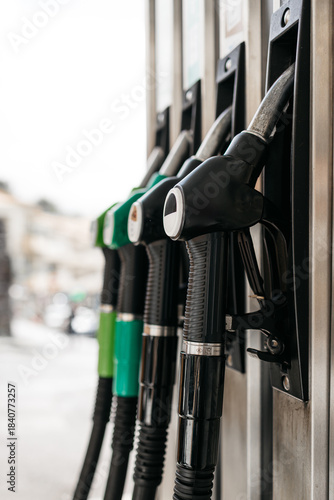 Cuadro en lienzo Fuel pump nozzles in various colors are displayed at a gas station, showcasing t