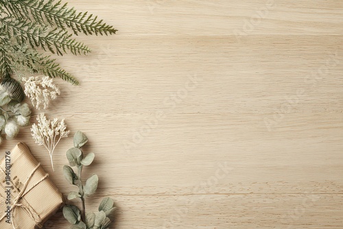 Rustic Christmas Gift Box with Greenery and White Berries on Light Wood Surface Top View