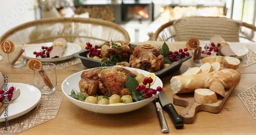 Camera is tilting upward from roast chicken bowl to reveal stove and Christmas tree, showing table