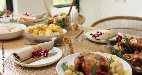 Camera is starting close on chicken platter and is panning to showcase festive table at window